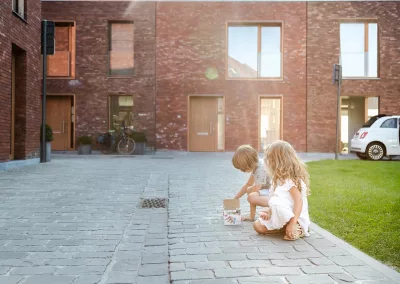 kinderen tekenen met stoepkrijt in een duurzame woonwijk